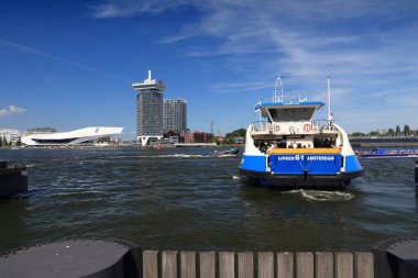 AMSTERDAM, NETHERLANDS - 9 Temmuz 2017: insanlar Amsterdam, Hollanda 'daki IJ körfezinden geçmek için feribota biniyor. Amsterdam Hollanda 'nın başkentidir..