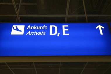 Frankfurt Havaalanı 'nda genel havaalanı tabelası. Aydınlatılmış gelenler işareti (İngilizce ve Almanca)).