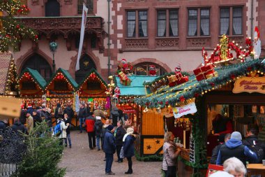 FRANKFURT, GERMANY - DECEMBER 6, 2016: People visit Christmas Market in Frankfurt, Germany. The tradition of Christkindlmarkt originates from Germany. clipart
