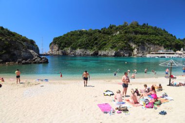 CORFU, GREECE - 2 Haziran 2016: İnsanlar Yunanistan 'ın Korfu Adası' ndaki Paleokastritsa plajının tadını çıkarıyor. 2012 yılında Korfu 'yu 558 bin turist ziyaret etti.