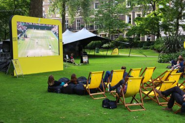 LONDON, İngiltere - 7 Temmuz 2016: İnsanlar İngiltere 'nin Grosvenor Square Park' ında halka açık Wimbledon tenis turnuvasının tadını çıkarıyor.