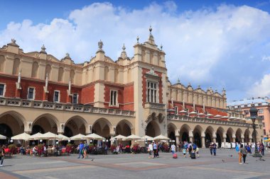 KRAKOW, POLAND - 28 Ağustos 2018: İnsanlar Polonya 'nın Krakow kentindeki Rynek Meydanı ve Kumaş Salonu' nu (Sukiennice) ziyaret ediyor. Krakow Tarihi Merkezi UNESCO 'nun Dünya Mirasları Alanıdır..