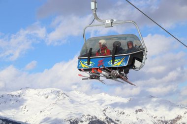HINTERTUX, AUSTRIA - 10 Mart 2019: İnsanlar Avusturya 'nın Tyrol bölgesindeki Hintertux Buzul Kayak Merkezinde bir asansöre biniyorlar. Merkez, Orta Doğu Alpleri 'nin Zillertal Vadisi' nde yer almaktadır (Zentralalpen).