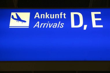 Frankfurt Havaalanı 'nda genel havaalanı tabelası. Aydınlatılmış gelenler işareti (İngilizce ve Almanca)).