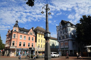 DORTMUND, GERMANY - 16 Eylül 2020: Dortmund 'un Hoste ilçesinde insanlar Schlanke Mathilde saatine yakın yürüyorlar. Schlanke Mathilde (Türkçe: Slim Mathilde) Marktplatz Meydanı 'nda bulunan tarihi bir saattir..