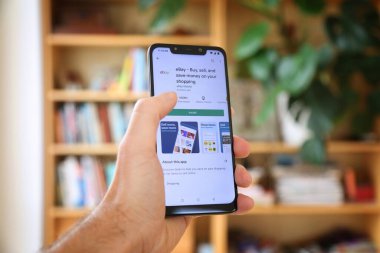 WARsaw, POLAND - 29 Ocak 2021: Android OS, Xiaomi markalı akıllı telefona eBay açık artırma pazarı mobil uygulaması yükleyen kullanıcı.