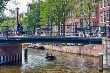 AMSTERDAM, NETHERLANDS - 7 Temmuz 2017: İnsanlar Hollanda, Amsterdam 'daki Lauriergracht Kanalı üzerinden köprüyü geçiyor.