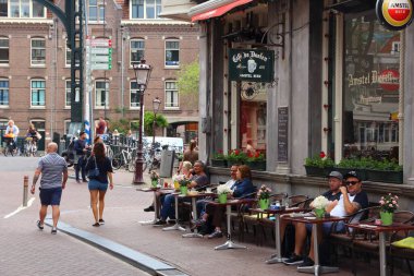 AMSTERDAM, NETHERLANDS - 8 Temmuz 2017: İnsanlar Hollanda, Amsterdam 'da bir kaldırım kafesini ziyaret ediyor.