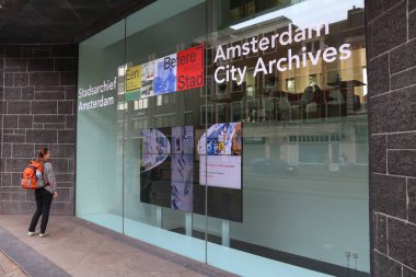 Amsterdam, Hollanda - 10 Temmuz 2017: Hollanda Amsterdam şehir arşivleri (Stadsarchief Amsterdam) insanlar yürümek. Arşiv De Bazel vardır anıtsal tuğla Ekspresyonizm bina.