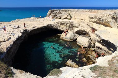 SALENTO, İtalya - 1 Haziran 2017 İnsanlar İtalya 'nın Salento Yarımadası, Roca' daki Grotta Della Poesia yüzme mağarasını ziyaret ediyor. Yıllık 50 milyon ziyaretçiyle İtalya, en çok ziyaret edilen ülkelerden biri oldu..