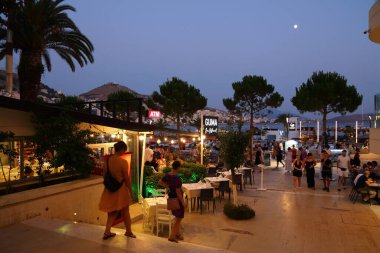 SARANDE, ALBANIA - 7 Temmuz 2025: İnsanlar Arnavutluk 'un güneyindeki Sarande tatil beldesindeki kafe ve restoranları ziyaret ediyorlar.