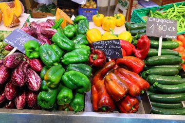 Patlıcan (patlıcan), çan biberi ve kabak, İspanya 'nın Alicante kentindeki yerel pazar salonu Mercat Central' daki yeşil bakkal standında. İspanyol yemeği.