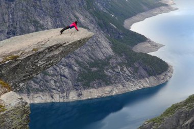 TROLTUNGA, NORway - 16 Temmuz 2015: Turistler Norveç 'in Hordaland ilçesindeki muhteşem Trol Dili (Trol' ün Dili) kayasını ziyaret ettiler. Trolltunga 'ya giden 22 km' lik patika Norveç 'te en çok ziyaret edilenler arasında.