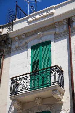 İtalya, Sicilya 'daki Messina şehrinde. Via San Filippo Bianchi Caddesi manzaralı. Bir balkonun yeşil kepenkleri.