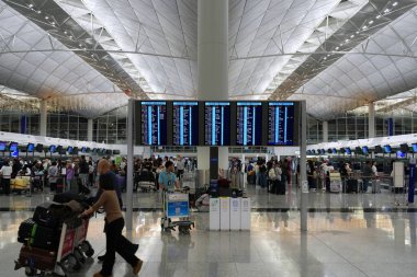 Hong Kong, Çin - 17 Kasım 2025 Yolcular, dünyanın en işlek havaalanlarından biri olan Hong Kong Uluslararası Havaalanı 'nın terminalini ziyaret etti..