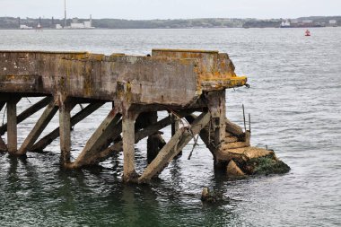 Çöken altyapı deniz suyu ve havadan zarar gördü. İrlanda 'daki Cobh limanında beton döküntüsü (aynı zamanda beton kanser olarak da bilinir).