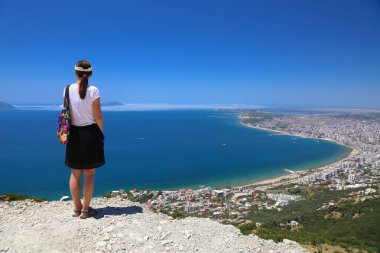 Turist kadın Adriyatik Denizi ile Vlore şehir manzarasını ziyaret ediyor. Arnavutluk 'un Vlore kentinde yaz.