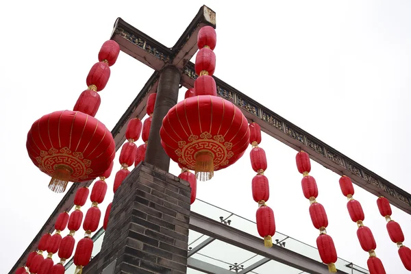 Смотреть вверх красные китайские фонари висят в стеклянном коридоре — стоковое фото