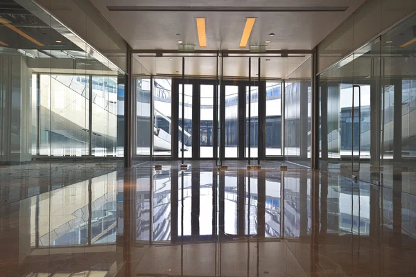 Интерьер современного здания с прозрачной стеклянной дверью — стоковое фото