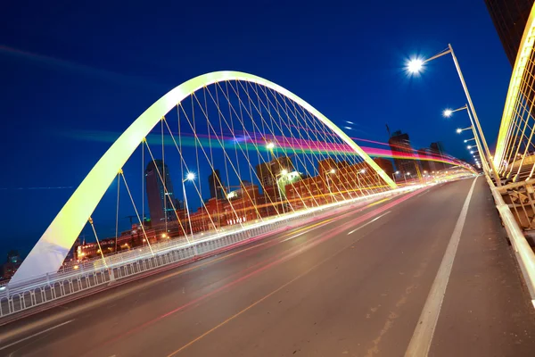 Дуговий міст вершник шосе автомобіль легкі стежки міста нічний пейзаж — стокове фото