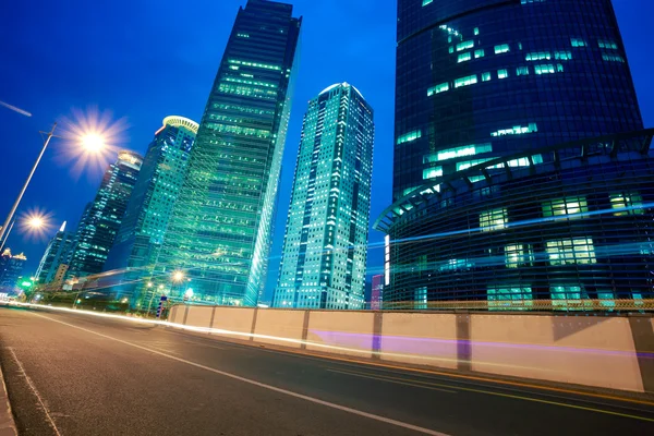 Senderos de luz de carretera en edificios de oficinas de paisaje urbano en Shangai — Foto de Stock