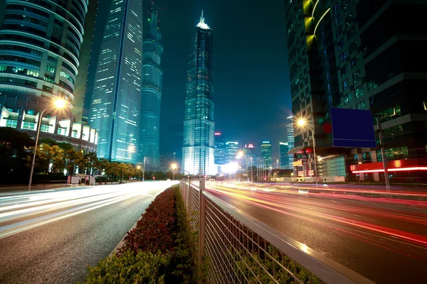 Senderos de luz de carretera en edificios de oficinas de paisaje urbano en Shangai —  Fotos de Stock