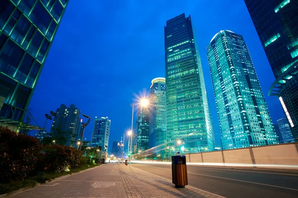 Senderos de luz de carretera en edificios de oficinas de paisaje urbano en Shangai — Foto de Stock