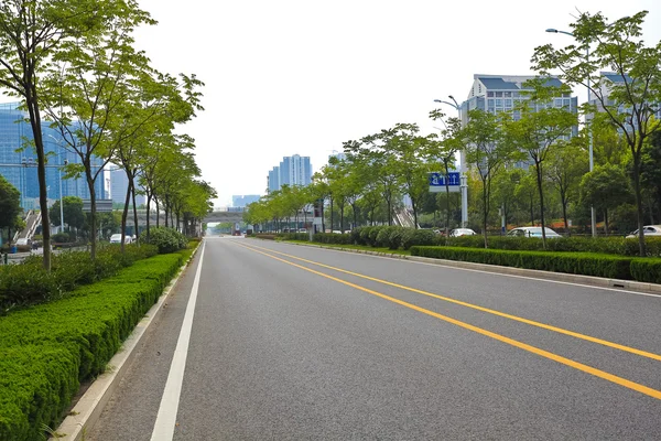 Empty road surface with modern city buildings background — Stock Photo, Image