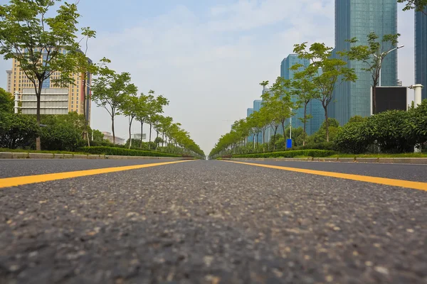 Empty road surface with modern city buildings background — Stock Photo, Image