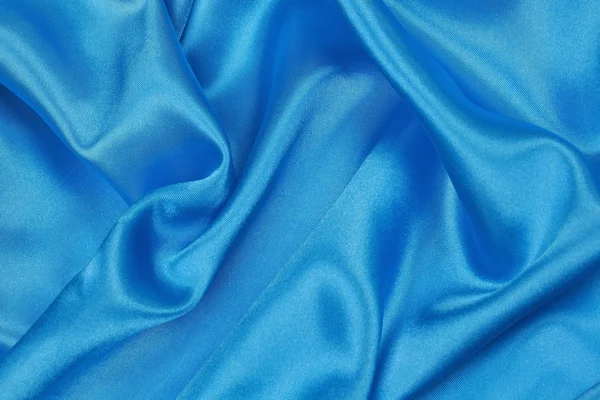 Синяя шелковая ткань волнистого абстрактного фона — стоковое фото