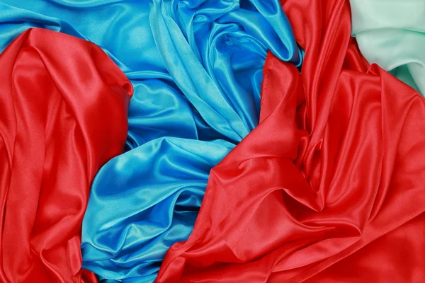 Material de terciopelo satinado de textura de seda azul y rojo y verde claro — Foto de Stock