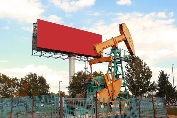 Golden yellow Oil pump and billboard of crude oilwell rig — Stock Photo, Image