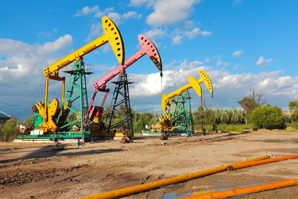 Bomba de aceite de oro amarillo y rosa de la plataforma de petróleo crudo — Foto de Stock