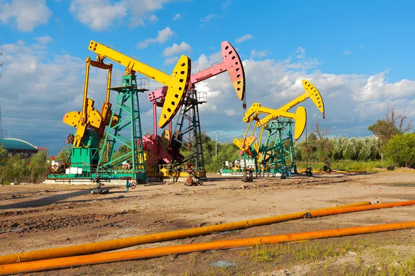粗野油井掘削装置のゴールデン イエローとピンク油ポンプ — ストック写真