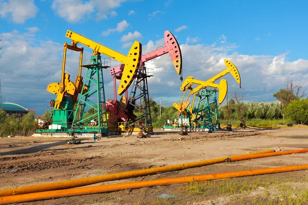 Zlaté žluté a růžové olejové čerpadlo ze surového oilwell plošiny — Stock fotografie