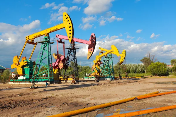 Bomba de aceite de oro amarillo y rosa de la plataforma de petróleo crudo — Foto de Stock