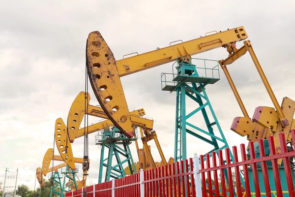 Bomba de aceite amarillo dorado y cartelera de plataforma de pozo petrolífero crudo — Foto de Stock