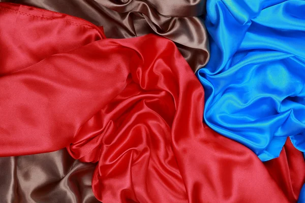 Blue and brown and red silk satin cloth of wavy folds texture ba