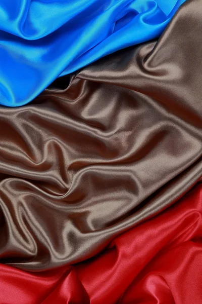 Blue and brown and red silk satin cloth of wavy folds texture ba — Stock Photo, Image