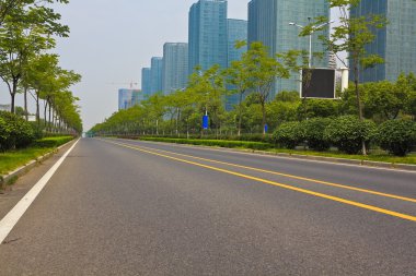 Boş yol yüzeyi ile modern şehir binaları arka plan