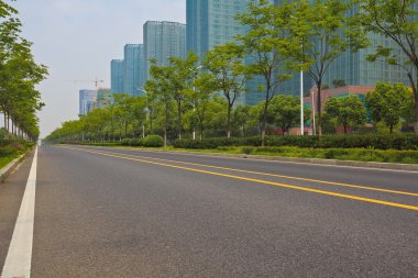 Boş yol yüzeyi ile modern şehir binaları arka plan