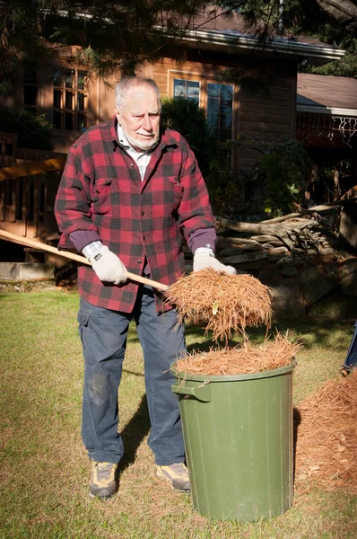 Limpeza sênior do quintal no outono — Fotografia de Stock