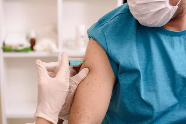Рука медичного персоналу, що вводить вакцину проти коронавірусу ковід-19 у вакцину проти м'язів рук — стокове фото