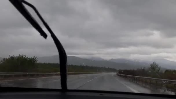 В пасмурную погоду водитель едет по шоссе при помощи дворников — стоковое видео