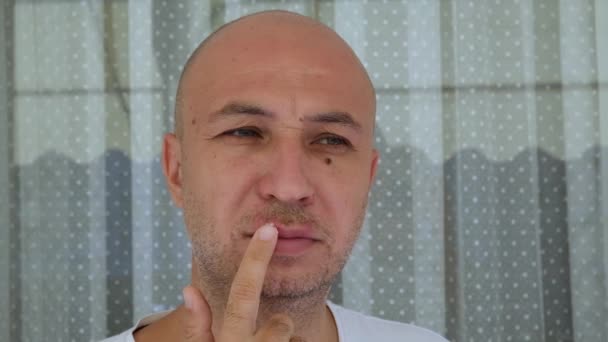 Man brengt een crème op herpes virus infectie op de lip met zijn vinger. Medische zorg slow motion video — Stockvideo