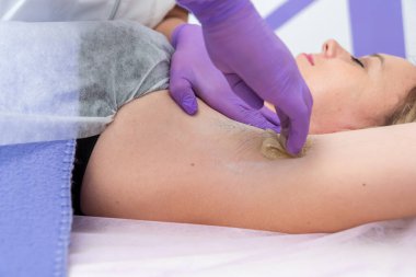 Şekerleme tüy temizleme konsepti. Spa salonunda şeker ezmeli, beyaz arka planda, koltuk altı kizinin işlem depilasyonu.