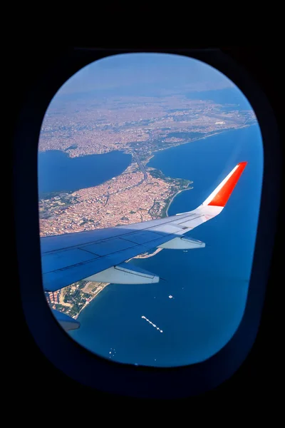 Looking through window aircraft during flight in wing lands over Istanbul in sunny weather
