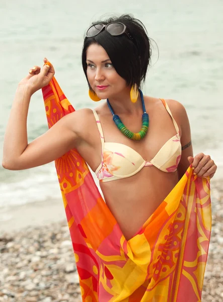 Vrouw in bikini en pareo op zee achtergrond — Stockfoto