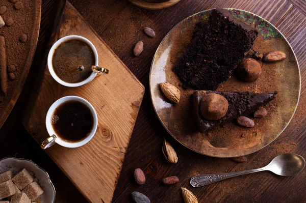 delicious chocolate truffles cakes with  cups of coffee served at dark brown wooden table . life style concept. flat lay