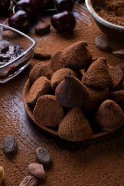 Sağlıklı ve lezzetli mantarlı sanat arkaplanı, çikolata ve besleyici maddeler: doğal kakao çekirdekleri, toz, çikolata, badem fıstığı ve olgun kiraz. sağlıklı tatlı konsepti. 